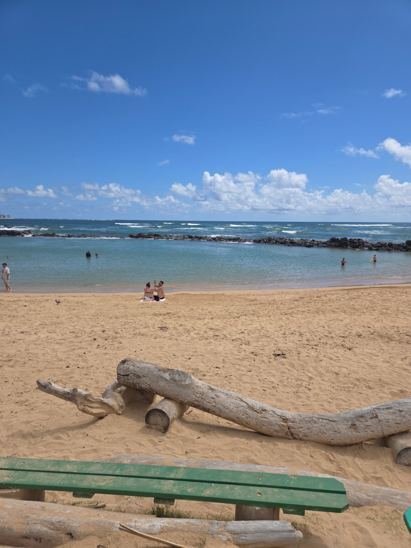Lydgate Beach back to itself, calm water, cleared sand, people back in the ocean.